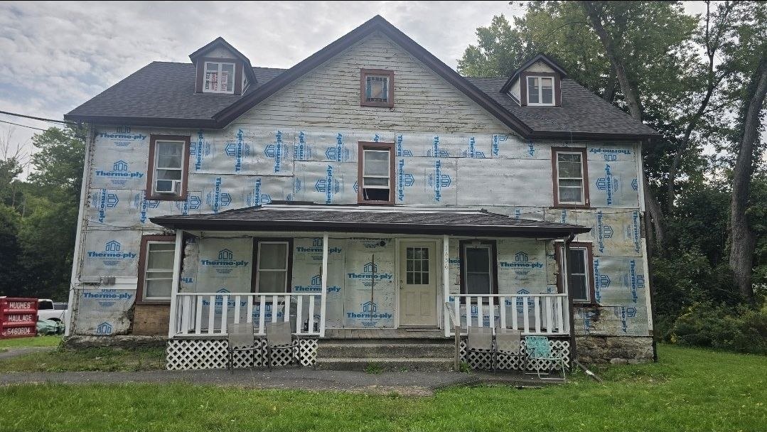 House before siding — old siding removed and house wrap exposed — J&R Enterprise